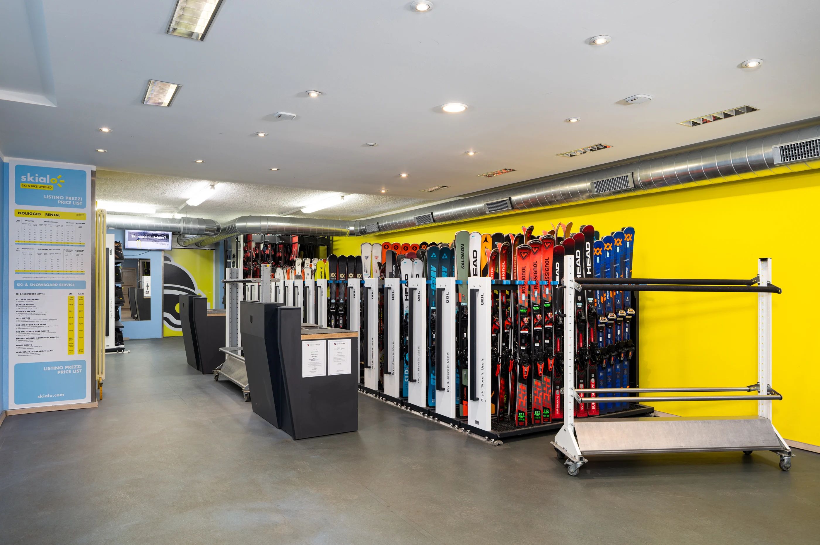 Intérieur du magasin de location Skialo à Livigno, avec les skis prêts à être retirés